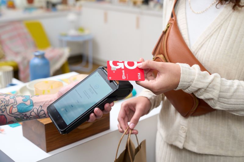 person using touch and pay on credit card terminal