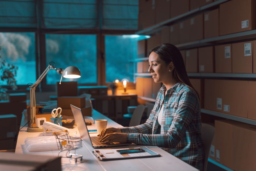Woman working late on laptop at business