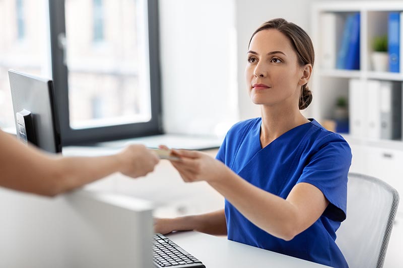 Female doctor taking payment from patient.