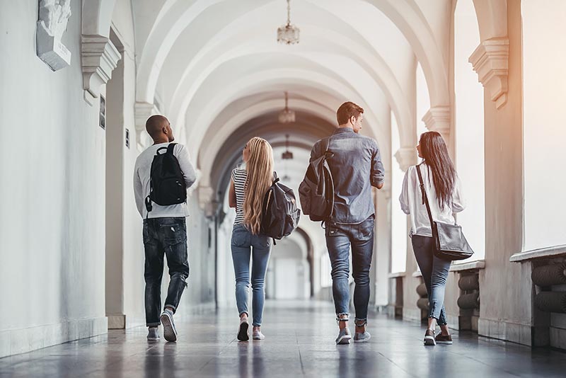 Four students walking down at school. 