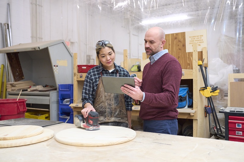 Two people looking at a tablet in a workshop