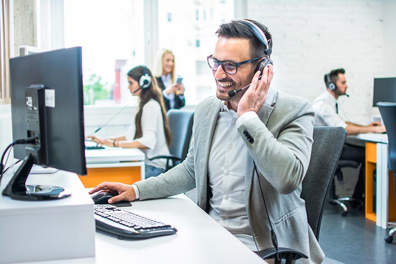 Customer service rep at a computer with headset.