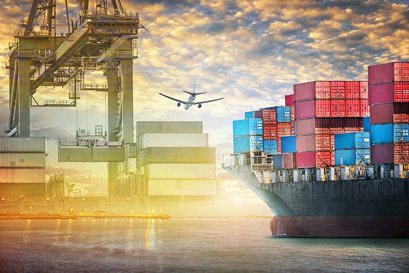 Plane flying over freight shipping docks. 