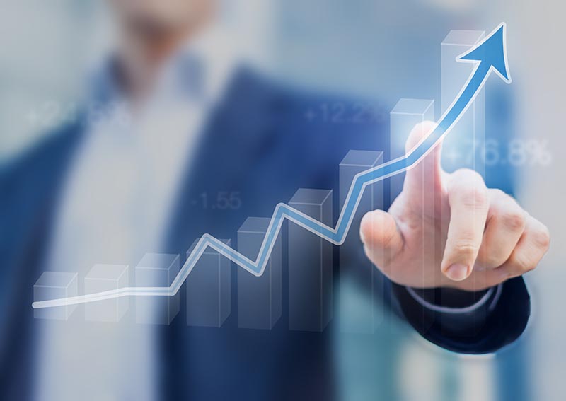 Businessman following graph that is trending up. 