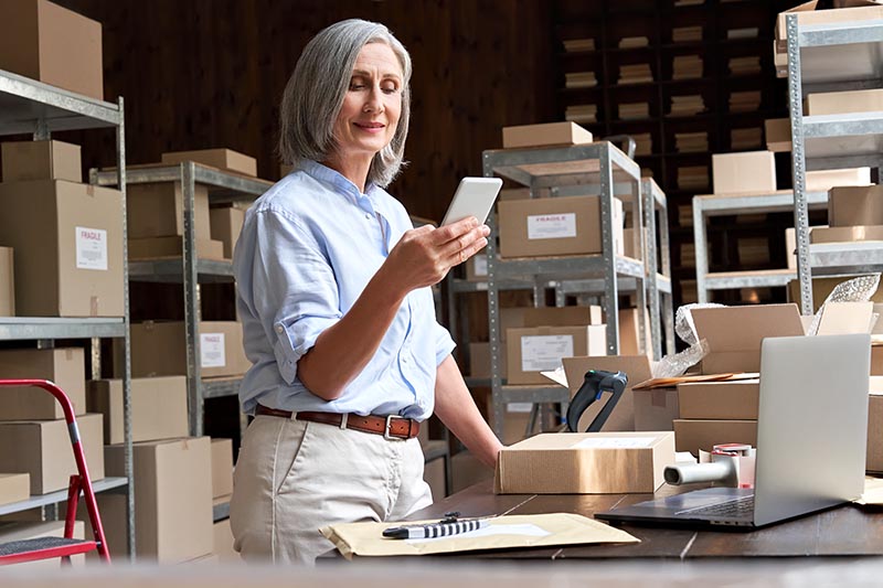 Small business owner managing sale orders on phone. 
