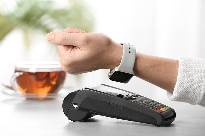 Someone using contactless payment with smartwatch. 